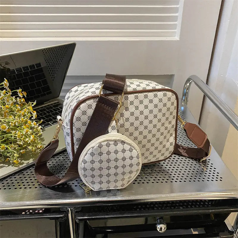 Beige and brown patterned vintage monogram shell crossbody bag with a matching circular coin pouch displayed on a white background.