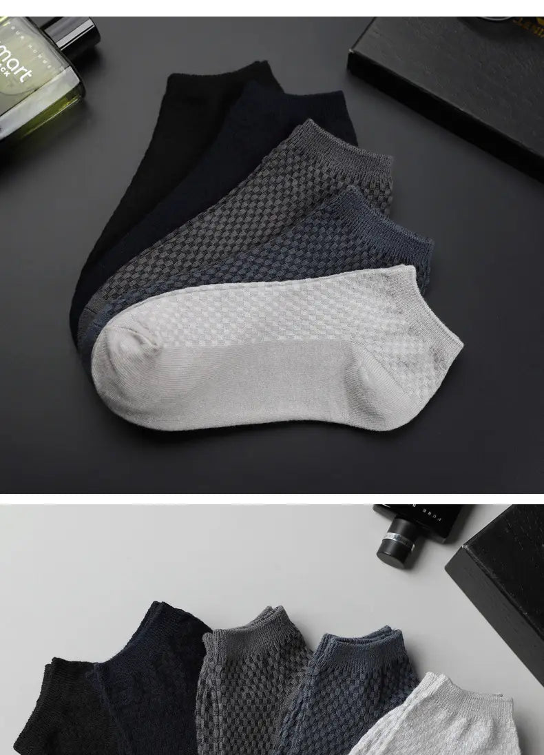 Set of four men bamboo fiber ankle socks in black gray navy blue and white with a textured knit pattern.