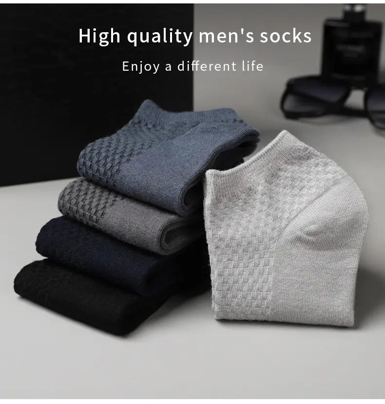 Stack of men bamboo fiber ankle socks in navy gray black and light gray with a textured weave pattern.