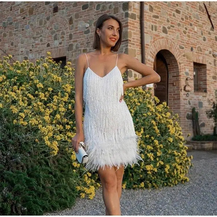 A white sequin feather tassel mini dress with a v-neckline, thin spaghetti straps, and delicate beaded detailing along the bodice for party wear.