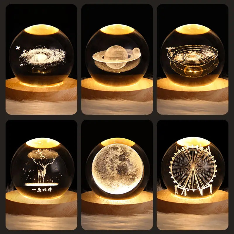 Clear glass 3d galaxy crystal ball led night light with intricate laser-engraved celestial and scenic designs illuminated by warm yellow light.
