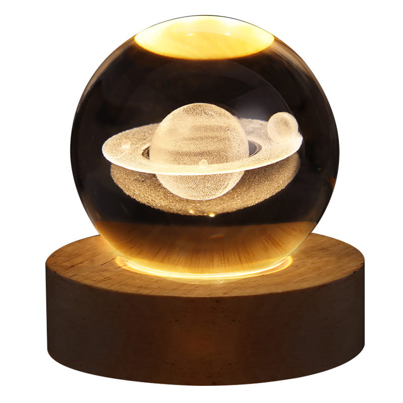 A warm-glowing transparent spherical led night light made of crystal featuring a detailed saturn model with rings and moons inside, ideal as a 3d galaxy crystal ball moon lamp.