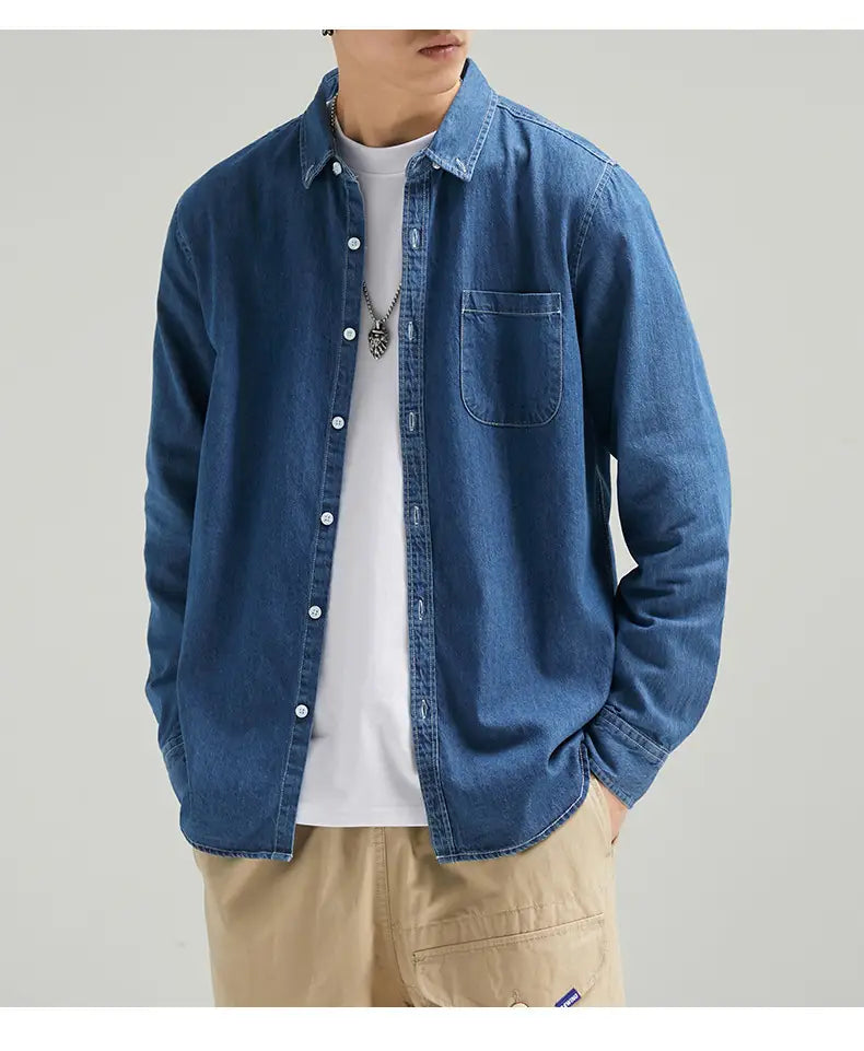Herren-Langarm-Jeanshemd im Casual-Stil mit Knopfleiste mit blauem Jeansstoff, weißen Knöpfen und einer Brusttasche.