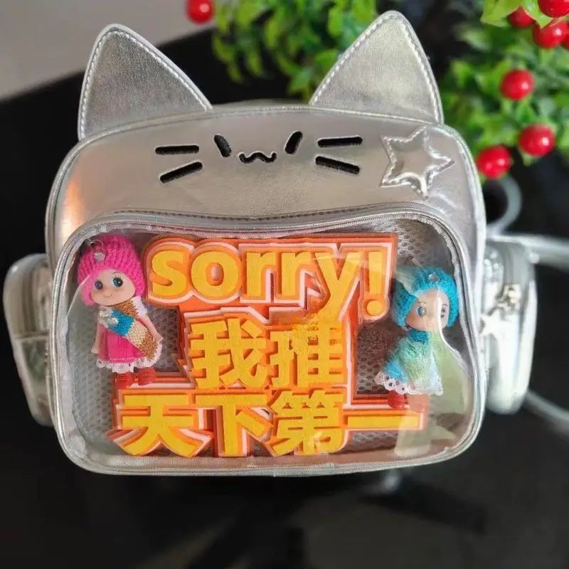 Silver cat-shaped crossbody bag with clear ita panel front displaying orange 3d text and two small figurines designed as a cat messenger bag.