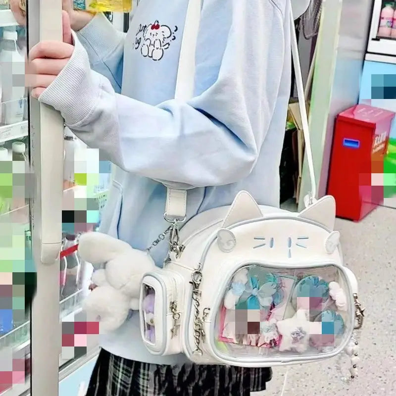 white cat-shaped crossbody bag with clear ita window panels and fluffy white accessories designed as a cat messenger bag
