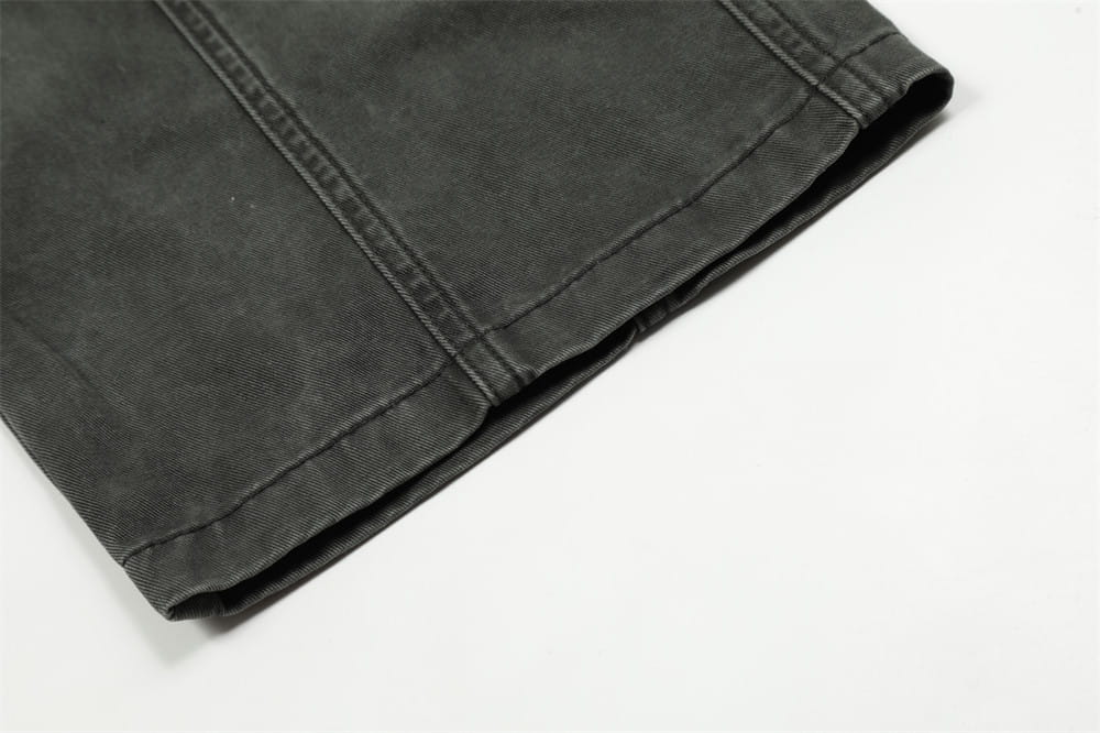 Salopettes cargo en jean de coton gris foncé à coupe slim pour homme, multi-poches, avec des coutures visibles le long de la couture sur le tissu denim.