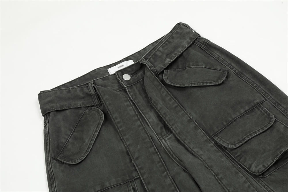 Salopettes cargo en jean de coton gris foncé à coupe slim pour homme, avec plusieurs poches et une fermeture par bouton.