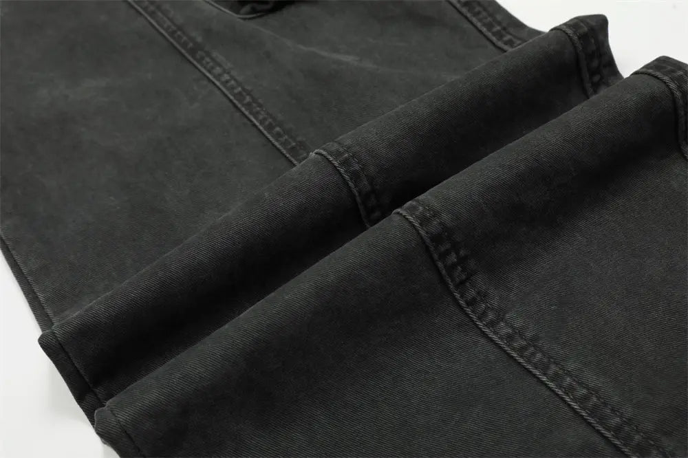 Salopettes cargo en jean de coton noir à coupe slim pour homme, multi-poches, avec une texture délavée et usée, et des coutures renforcées le long des coutures.
