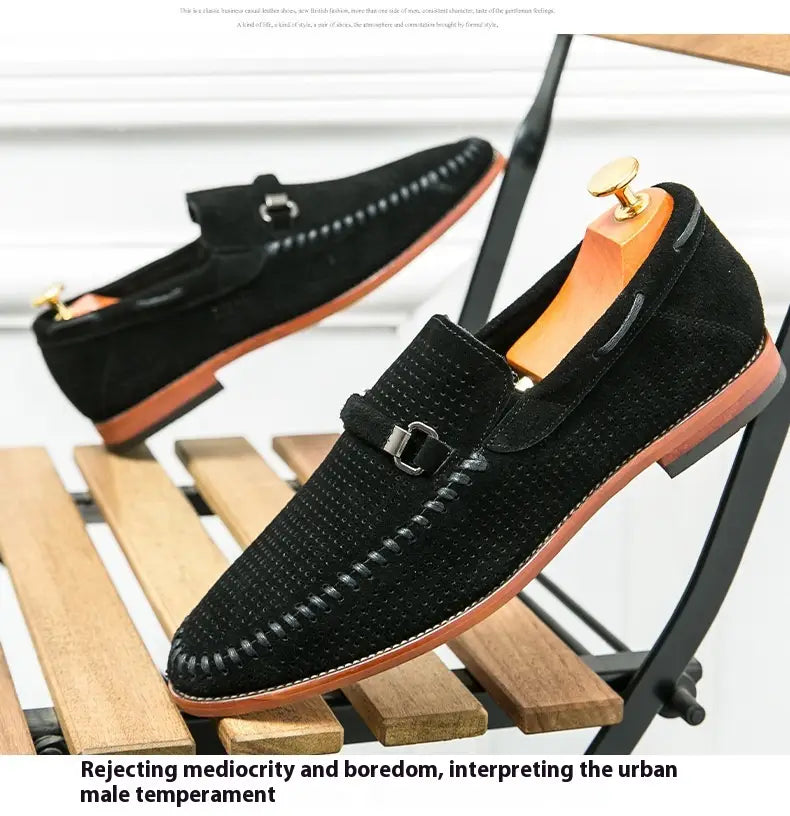 Mocasines de cuero tipo ante negro con suelas de cuero color camel y textura perforada, con hebillas metálicas de tono dorado, estilo mule.
