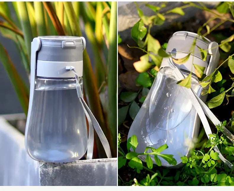 Transparent plastic portable pet water bottle with gray lid and matching strap featuring a carbon filter for clean drinking water.