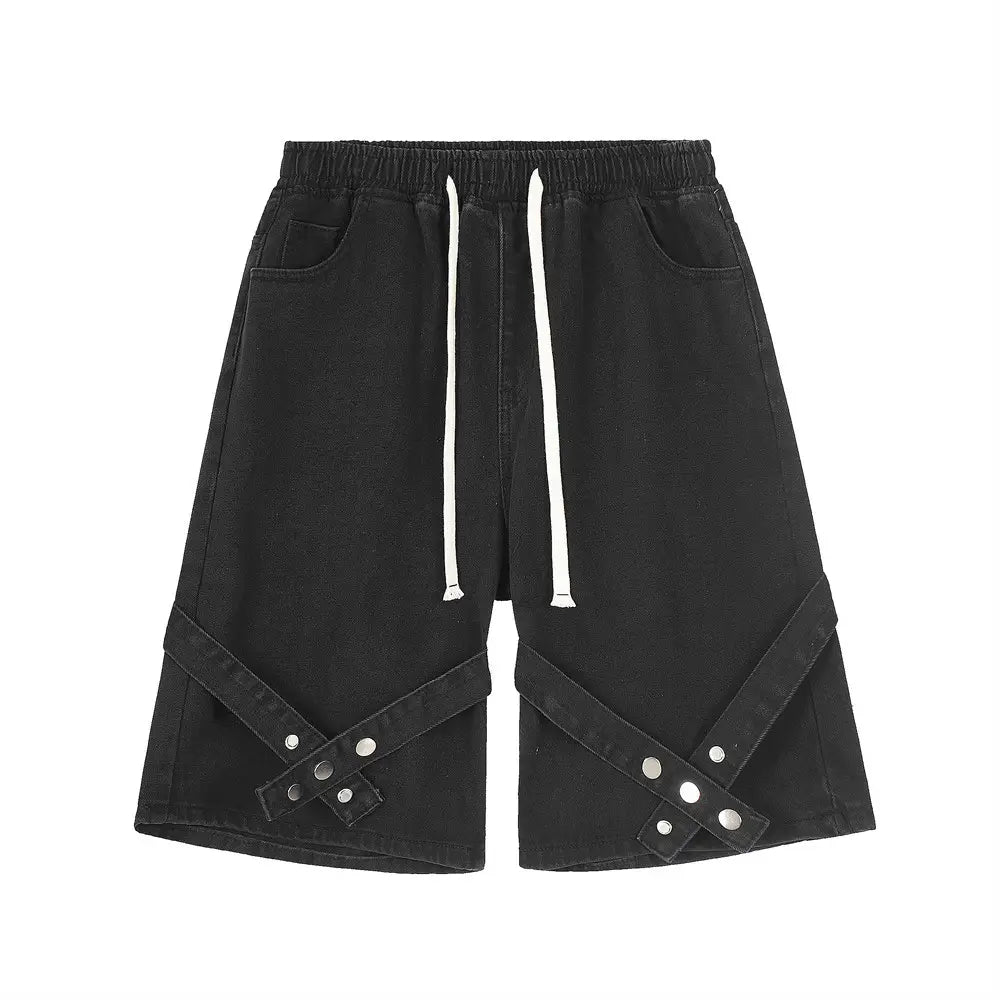 Shorts en jean noirs pour hommes, avec taille à cordon blanc et rivets métalliques à tonalité argentée sur les bretelles en tissu diagonales.