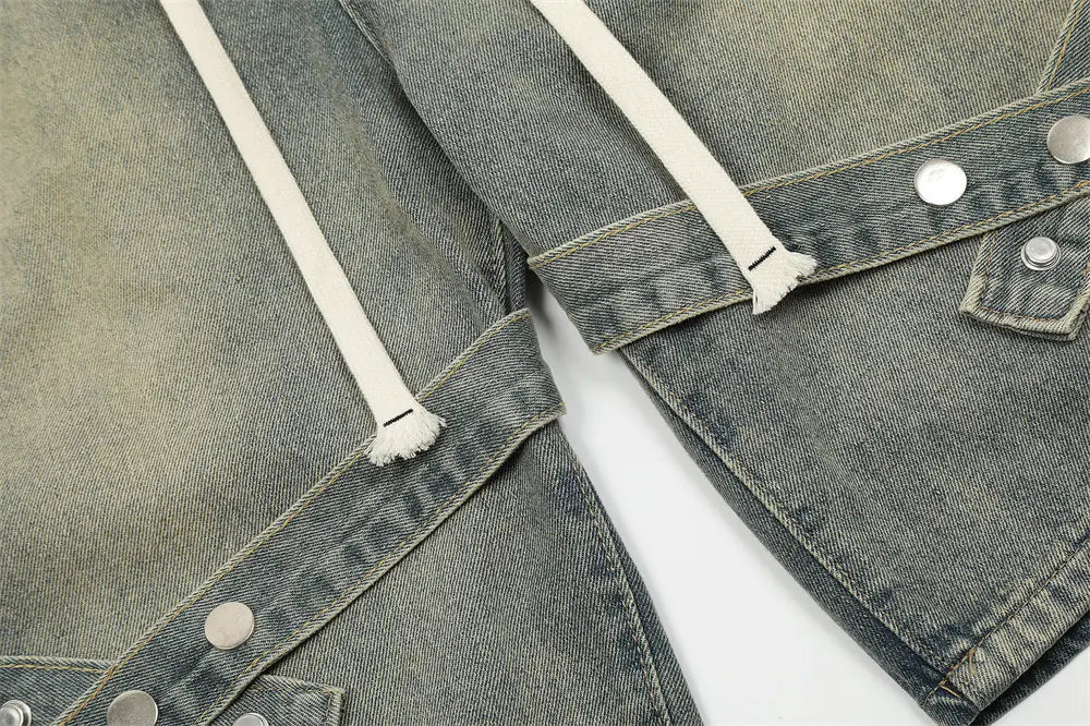 Veste en jean gris délavé, avec des cordons blancs et des boutons pression argentés, assortie à des shorts en jean pour hommes à bretelles diagonales et taille à cordon.