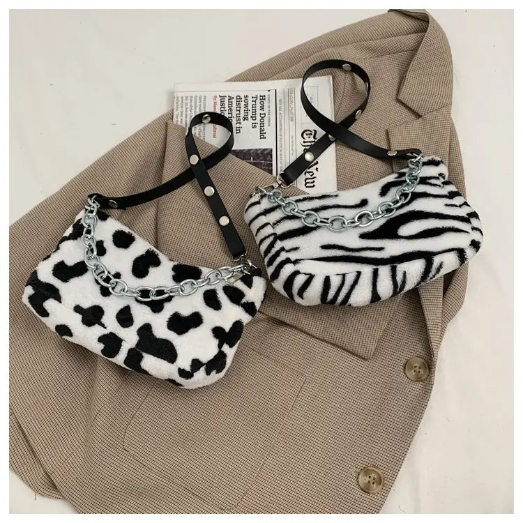 two plush animal print baguette bags with silver chain straps featuring black and white leopard and zebra stripe patterns