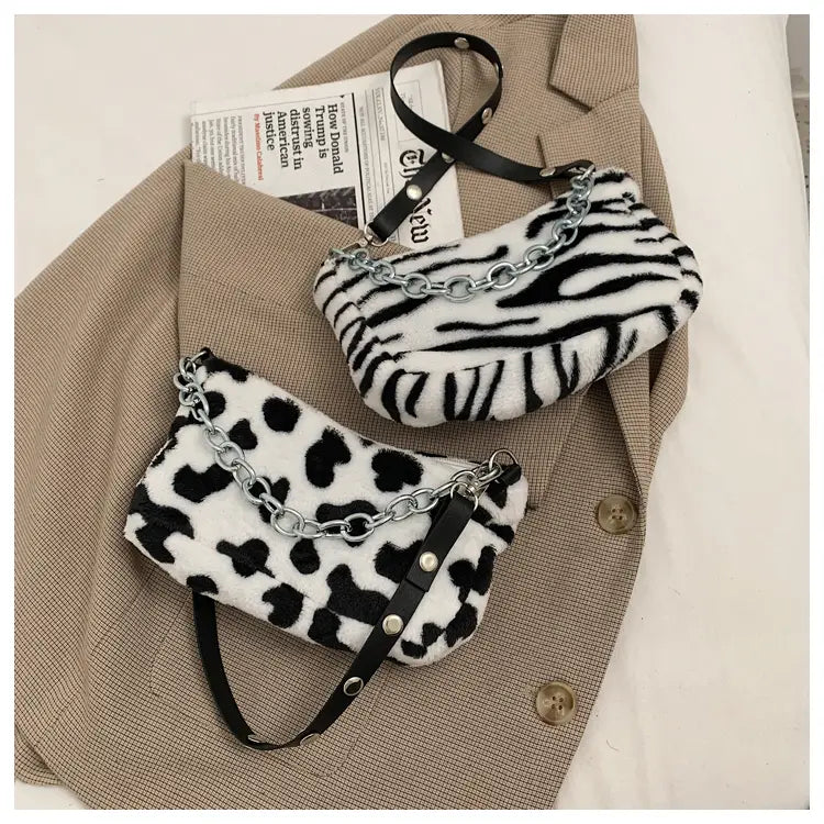 Plush animal print baguette bags in black and white zebra print and leopard print faux fur with silver chain straps.