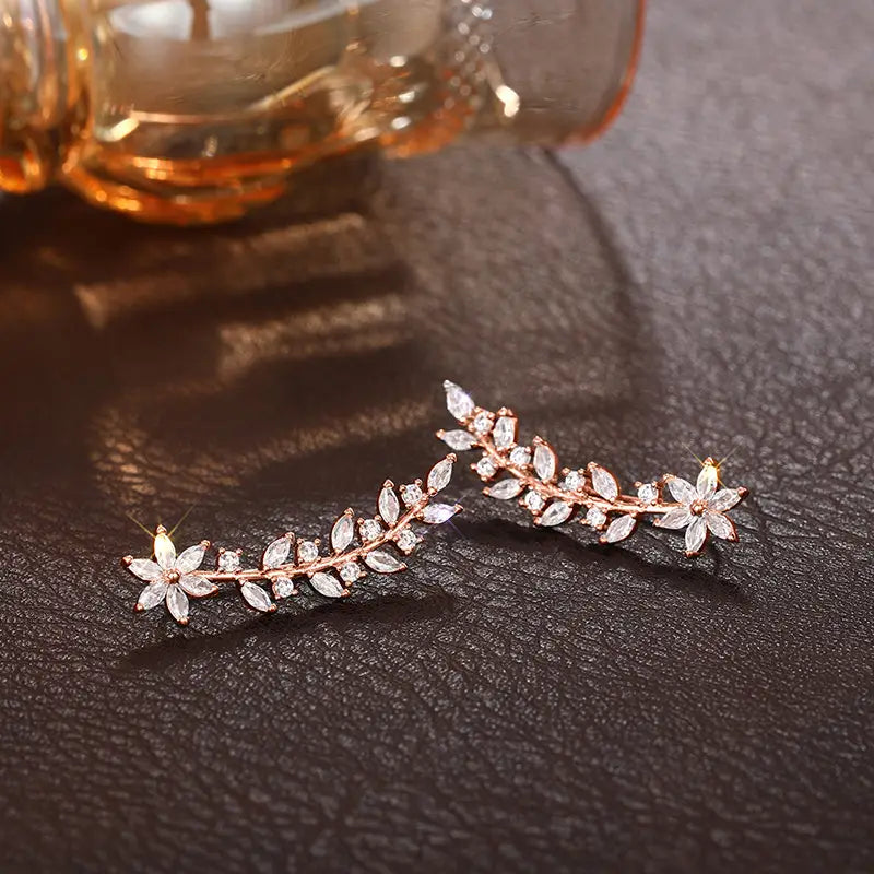 Rose gold leaf and flower design ear cuffs adorned with clear crystals called crystal floral vine ear climber earrings for women.