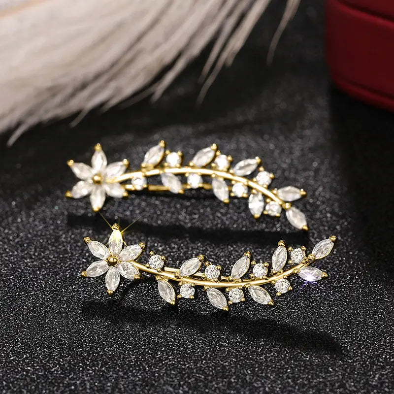 Gold-toned ear climber earrings for women adorned with clear faceted crystals arranged in a delicate leaf and flower design.