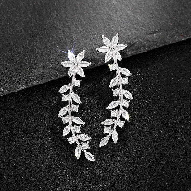 Crystal floral vine ear climber earrings for women featuring silver vine-shaped dangles adorned with clear faceted crystals forming a floral and leaf pattern.