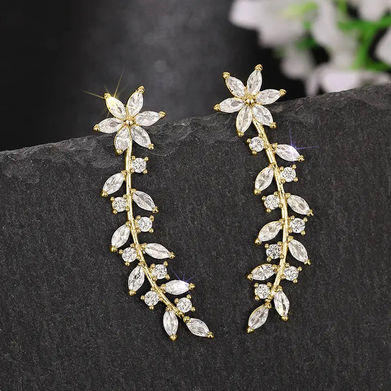 Crystal floral vine ear climber earrings for women featuring gold-toned leaf and flower drop design adorned with clear faceted crystals.