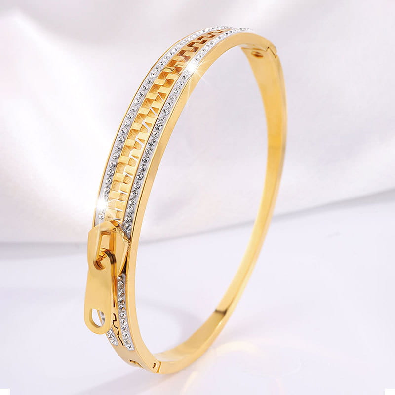 Gold-colored crystal interlocking titanium steel zipper bangle bracelet with a textured interwoven pattern and diamond-set edges.