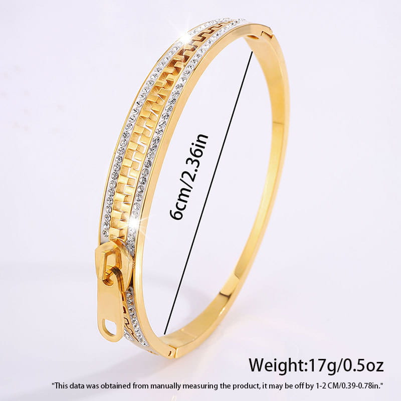 Gold-toned crystal interlocking titanium steel zipper bangle bracelet with textured chain design and clear crystal embellishments along its length.