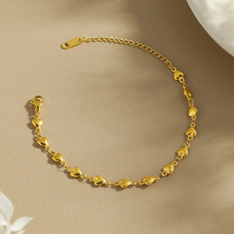 Polished gold heart link bracelet in titanium steel featuring a gold-colored heart-shaped charm anklet with a secure clasp and delicate chain links.