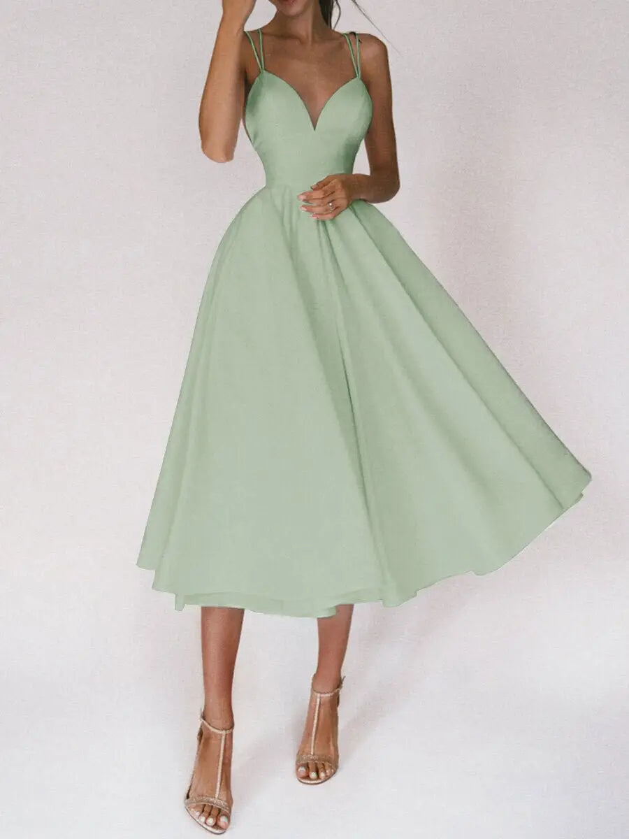 A flowing mint green satin a line midi dress with a v neck and thin spaghetti straps featuring a fitted bodice.
