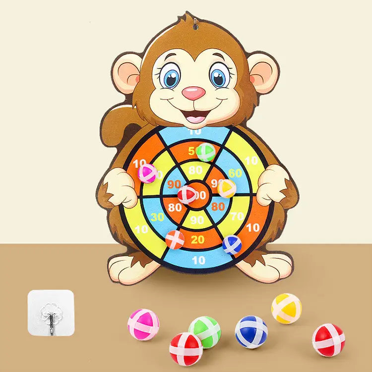 ein fröhlicher Cartoon-Affe in Form eines Klebe-Dartbretts für Kinder mit bunter, segmentierter Zielscheibe und kleinen Plastikkugeln, die herumliegen, für spielerisches, interaktives Spielen.