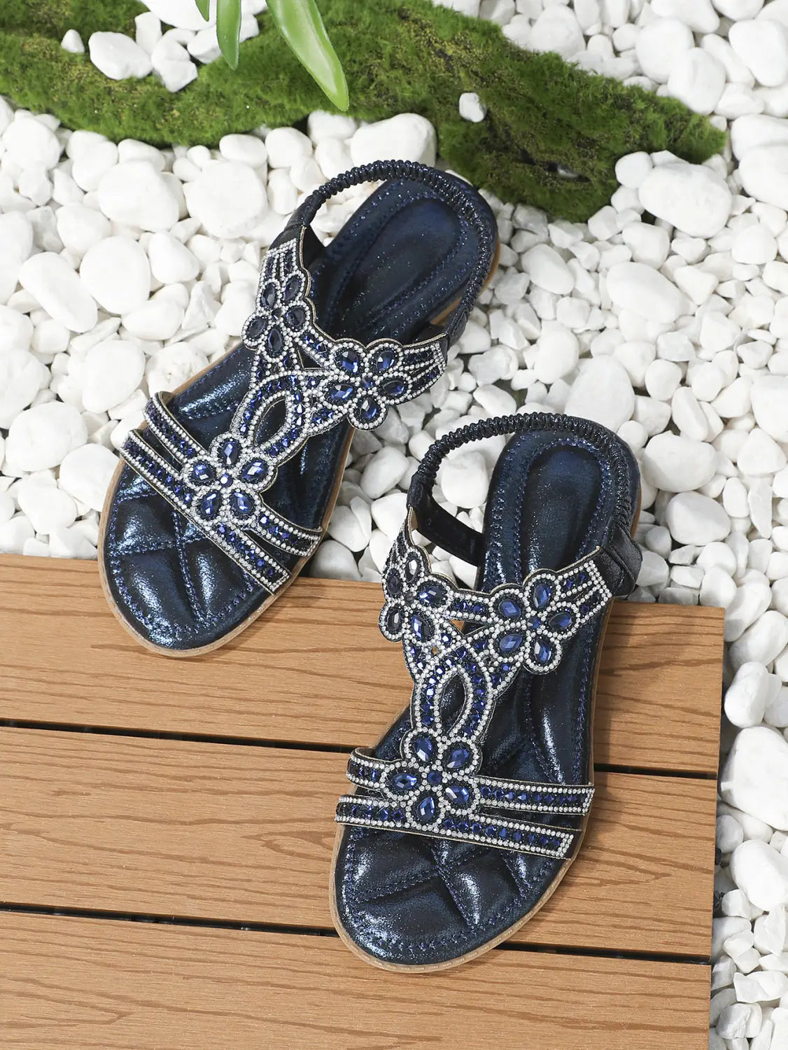 Sandalias tipo cuña de pedrería con flores para mujer en azul marino con diseños florales de pedrería con cuentas plateadas en las correas y tacón bajo.