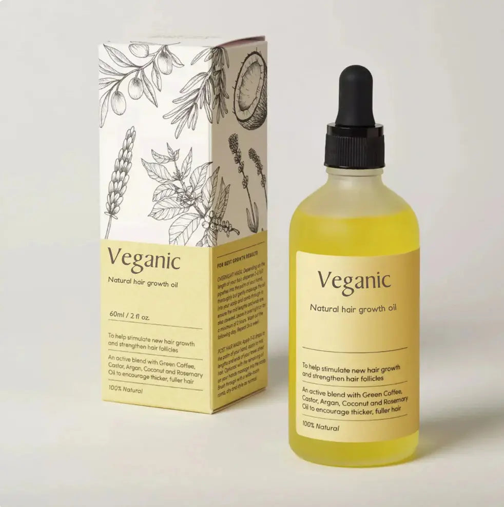 Veganic hair growth oil vegan natural essential treatment in a clear glass bottle with a black dropper cap filled with golden yellow liquid and a pale yellow label.