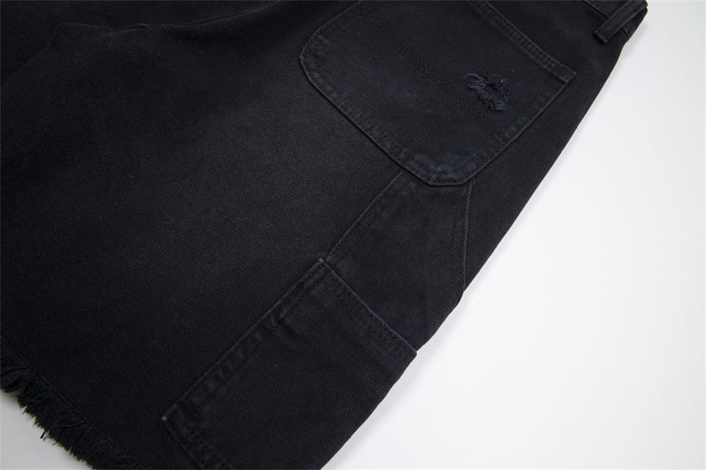 pantalones cortos de mezclilla negros para hombre con dobladillo deshilachado y detalles de bolsillos desgastados mostrados desde el lado posterior