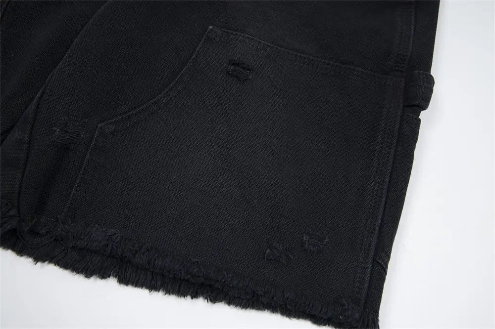pantalones cortos de mezclilla negros desgastados para hombre con dobladillo deshilachado y detalles sutiles de desgarro.