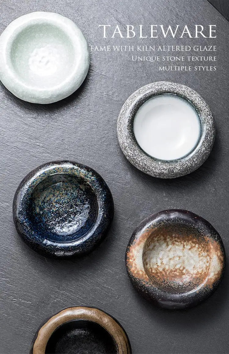 Handcrafted ceramic sashimi bowls and retro speckled hat plates with unique stone-like textures in soft white, speckled gray, deep blue, and rustic brown earthy glazes.
