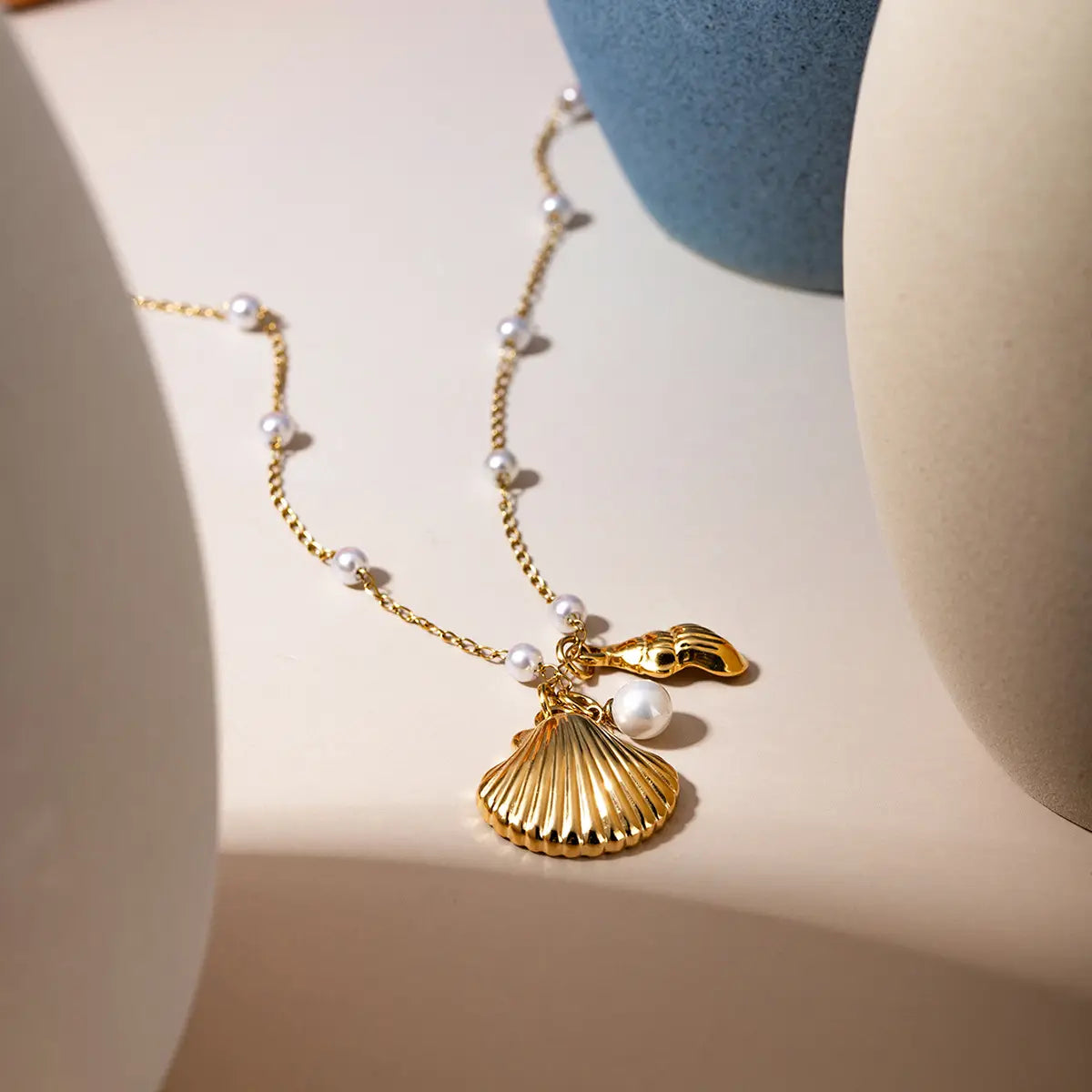 18k gold plated bracelet featuring a gold-toned seashell charm with a delicate chain and scattered pearls.