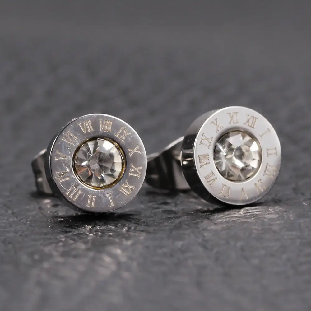 Boucles d’oreilles à tige à tonalité argentée comprenant un cristal transparent central, avec un cercle de chiffres romains gravés provenant de la parure de boucles d’oreilles à tige en diamant en or rose, motif de chiffres romains.