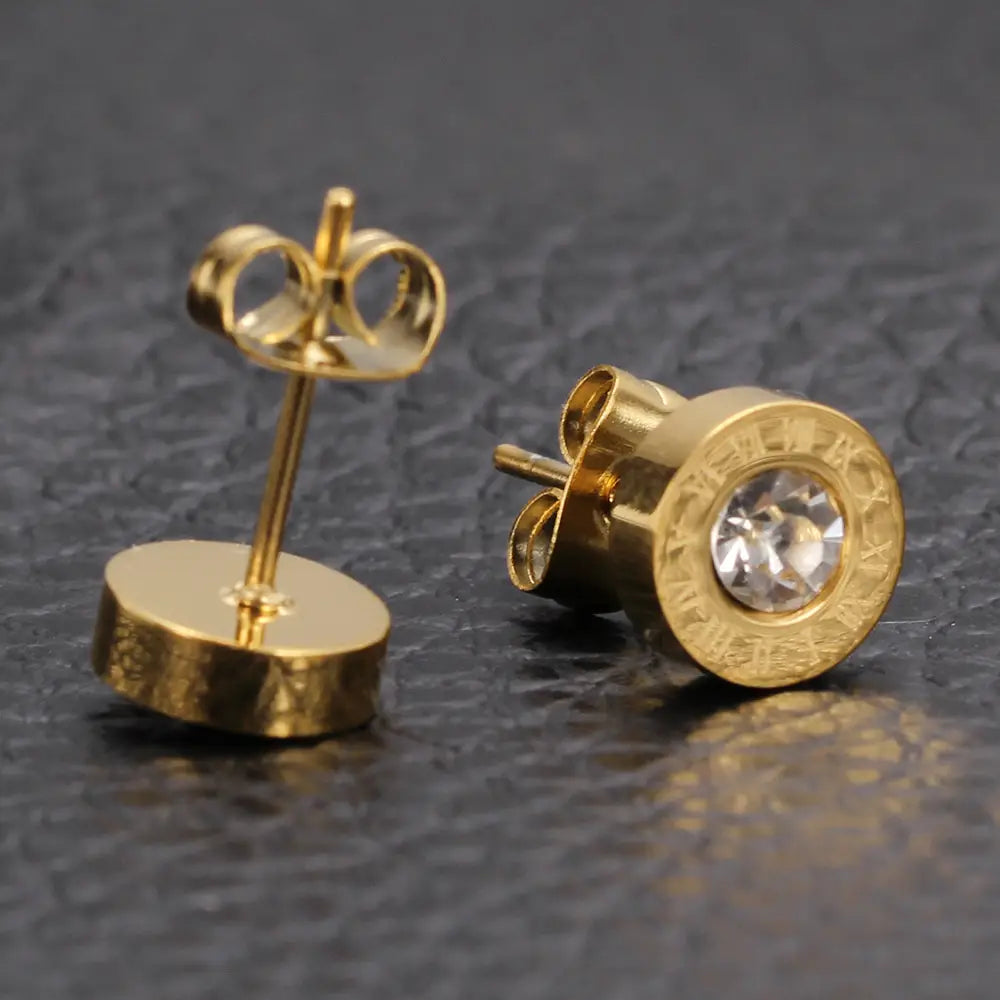 Boucles d’oreilles à tige en diamant en or rose, motif de chiffres romains, avec un design rond texturé à tonalité or et un centre en cristal transparent.