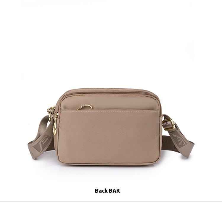 Beige nylon quilted crossbody bag with gold hardware and a subtle logo on the strap.