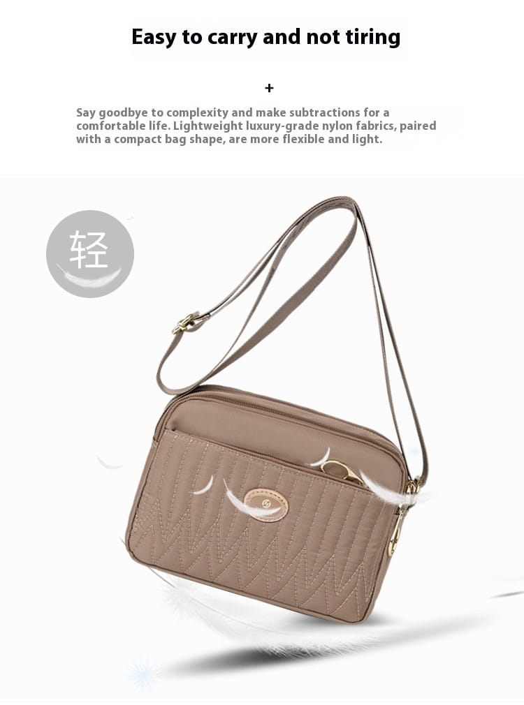 Beige quilted crossbody bag with gold-tone hardware and a subtle oval logo plaque designed for convenient hands-free use.