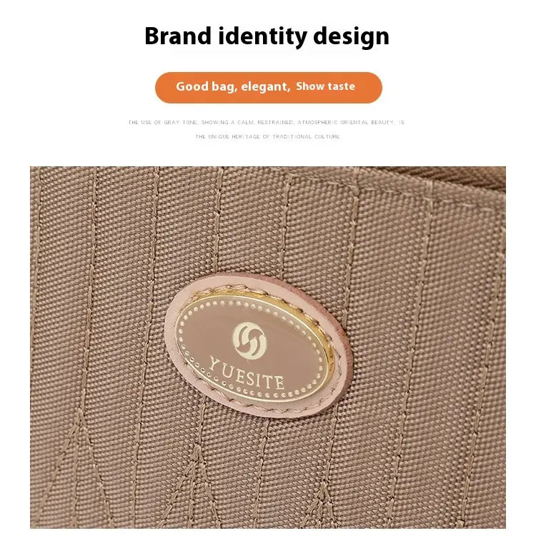 Beige textured fabric quilted crossbody bag with gold hardware and strap featuring a pink leather oval logo patch with the yuesite brand name and emblem.