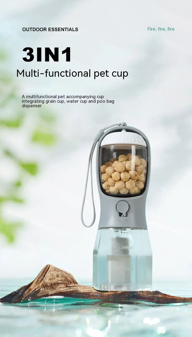 Gray and transparent 3-in-1 portable dog water bottle and food dispenser with handle designed for holding grain, water, and serving as a poo bag dispenser.