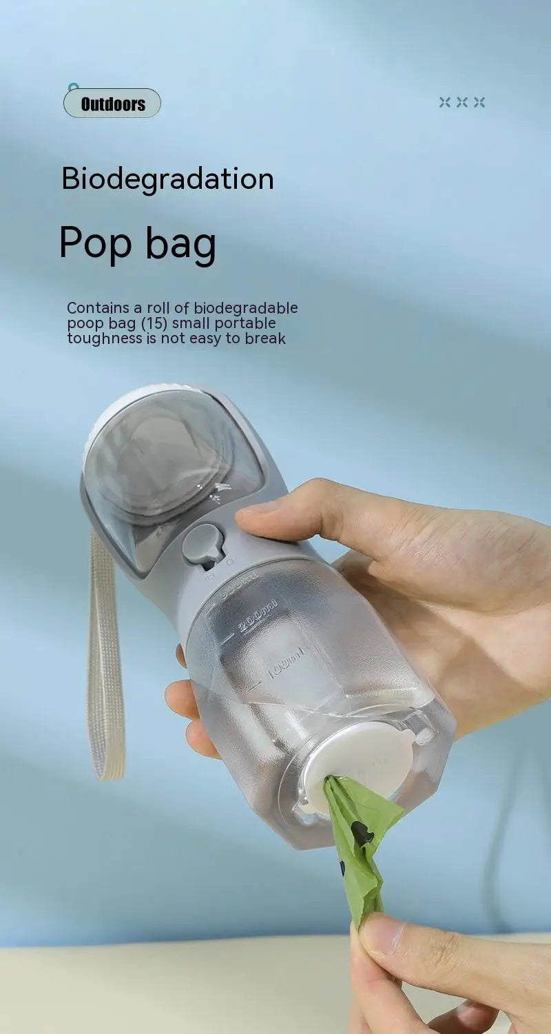Transparent plastic 3-in-1 portable dog water bottle and food dispenser with gray pump and handle designed for outdoor use and pet waste disposal.