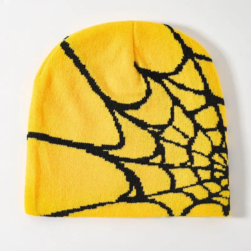 Bright yellow knit spiderweb beanie features a bold black pattern designed as a winter hat.