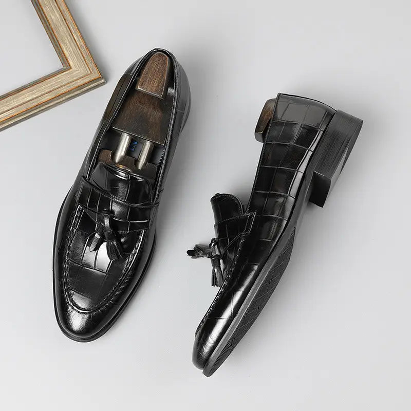 Mocasines de cuero con estampado de cocodrilo negro con acabado brillante y tacón bajo tipo bloque, vistos desde la parte trasera