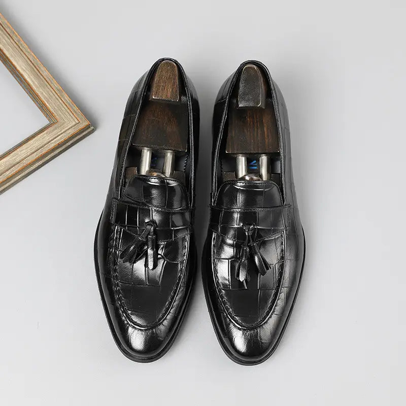 Mocasines de cuero con estampado de cocodrilo negro con acabado pulido y diseño clásico, mostrados desde la parte trasera