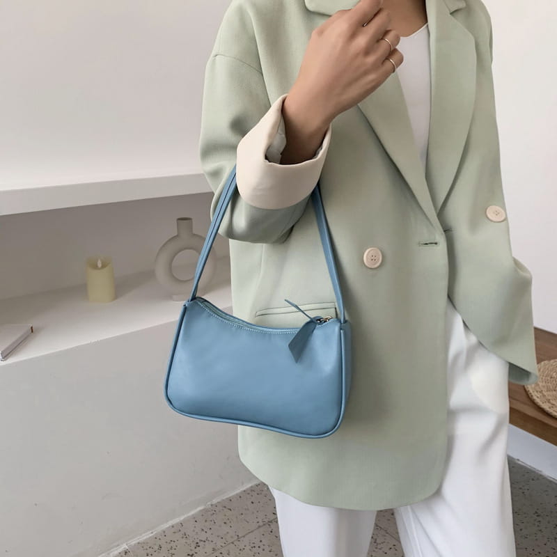 Underarm shoulder bag faux leather rectangular purse in light blue with a sleek curved design and matching strap.
