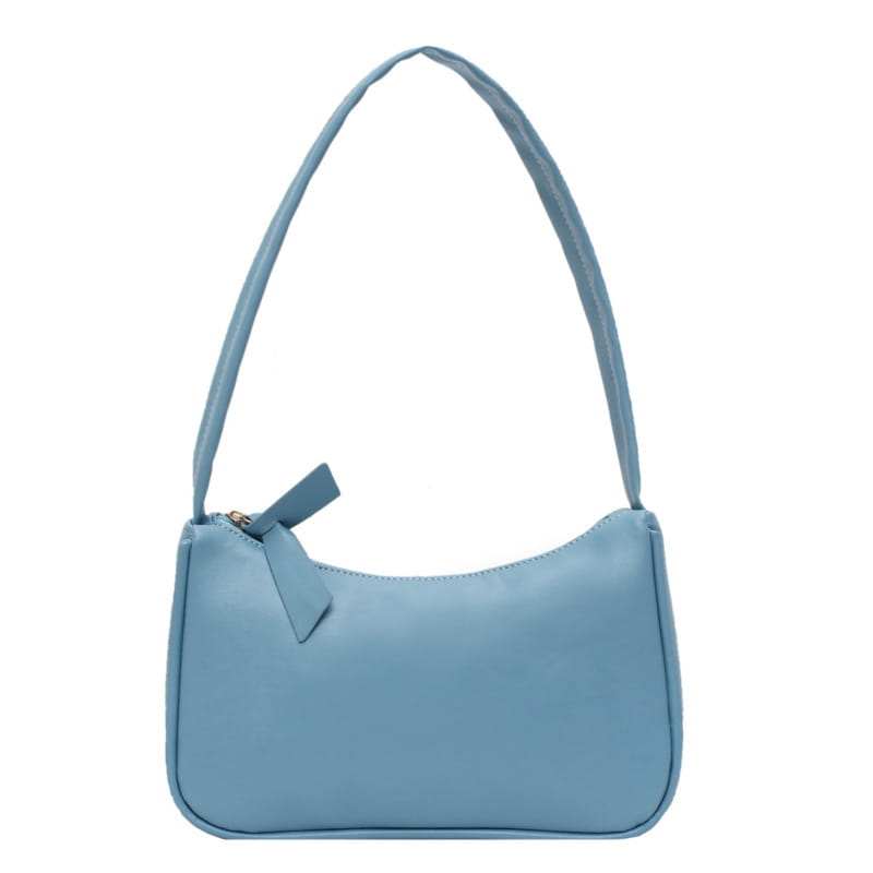 A soft light blue faux leather underarm shoulder bag with a rectangular shape and a matching fabric bow accenting the zipper pull.