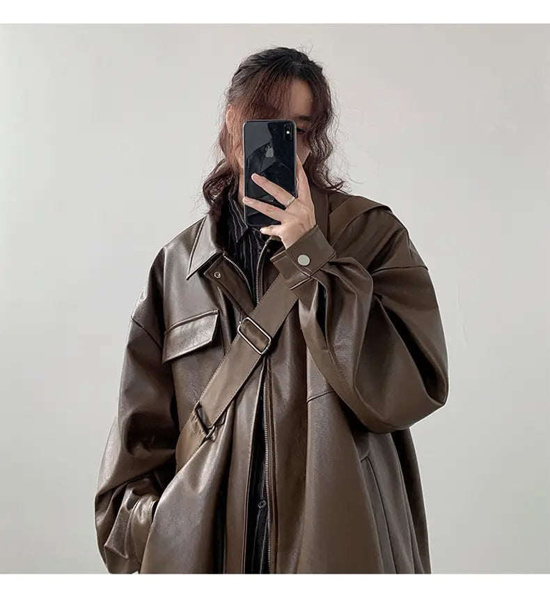 A brown faux leather loose trench coat with a relaxed fit, large patch pockets, and adjustable shoulder straps, suitable for casual spring and autumn wear.