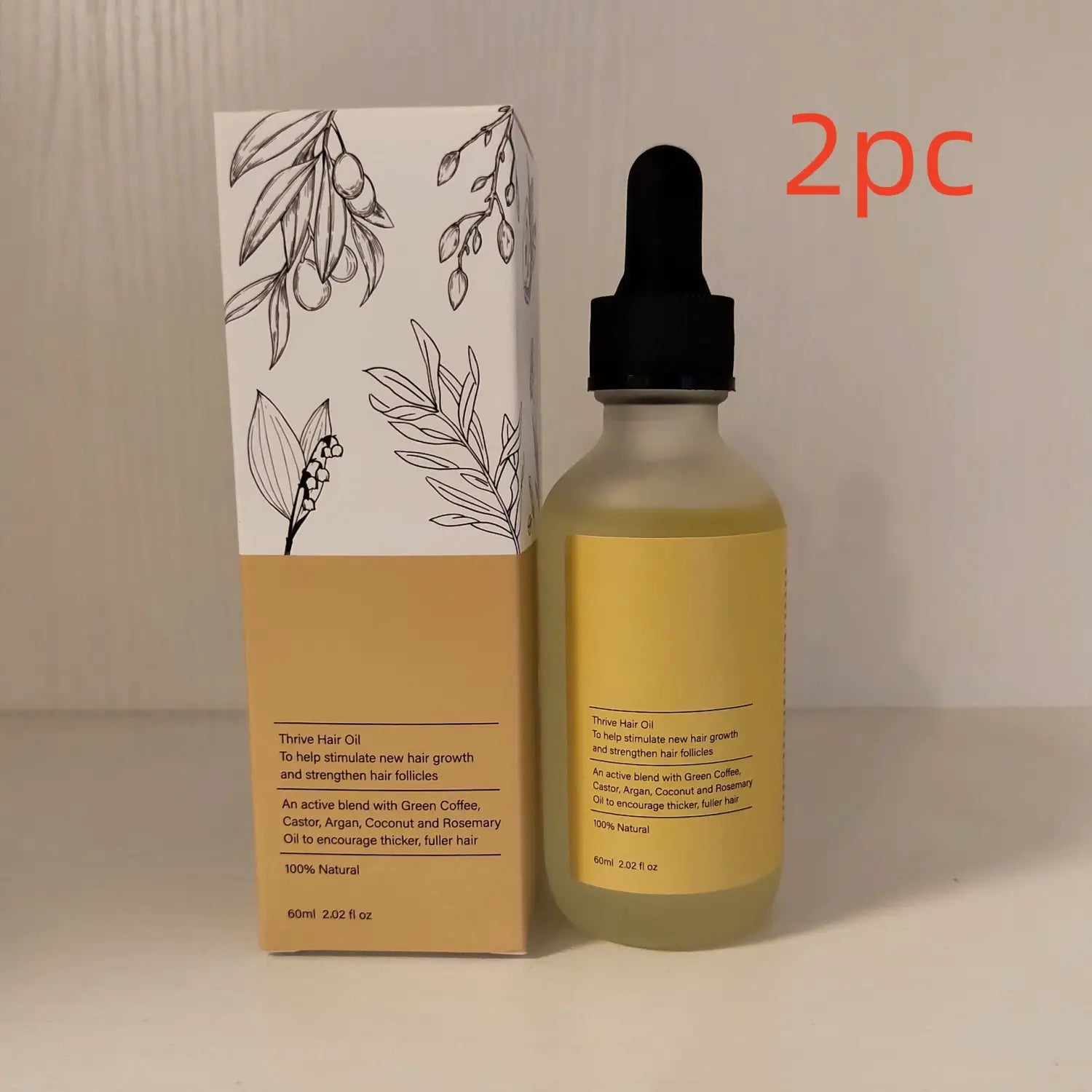 A clear glass bottle with a black dropper cap contains golden-yellow hair growth oil moisturizing repair serum 60ml positioned next to its beige and white botanical-themed box.