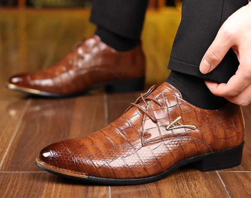 Men’s pointed toe formal leather business shoes in brown crocodile pattern with metallic toe cap and silver logo accent