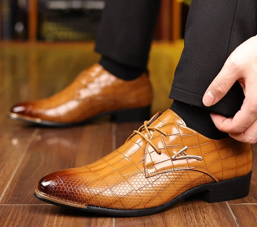Men’s pointed toe formal leather business shoes in brown crocodile pattern with metallic toe cap and silver logo accent