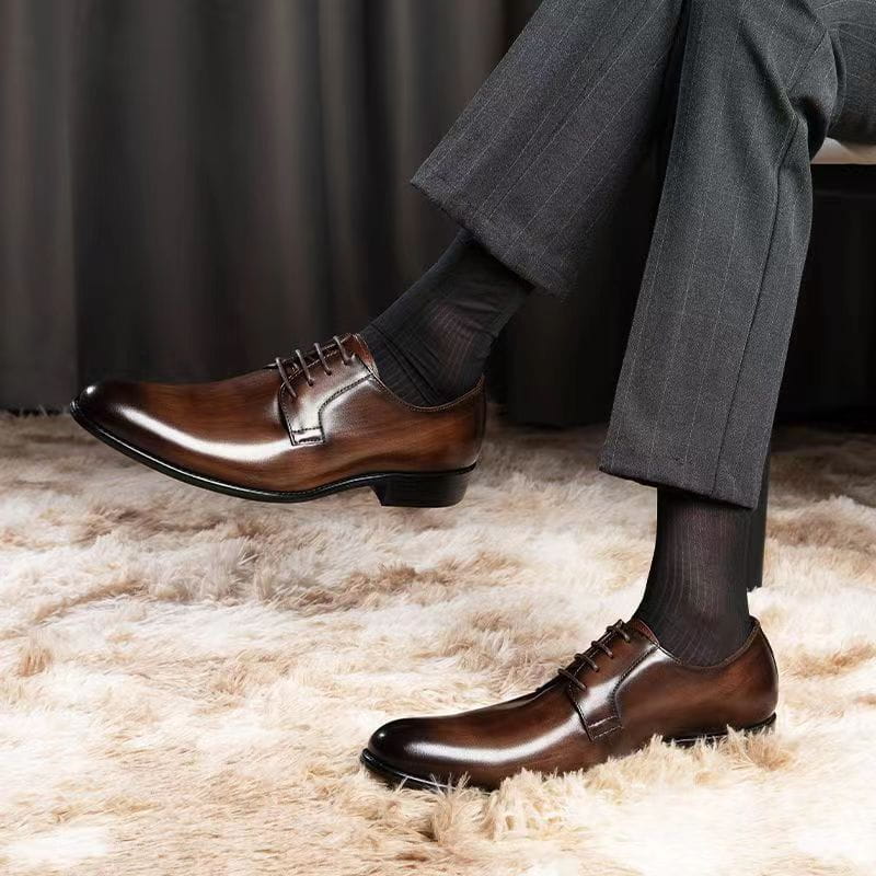 Herren-Oxfords aus handgeriebenem Leder in poliertem Braun mit Schnürverschluss und schwarzen Gummisohlen.
